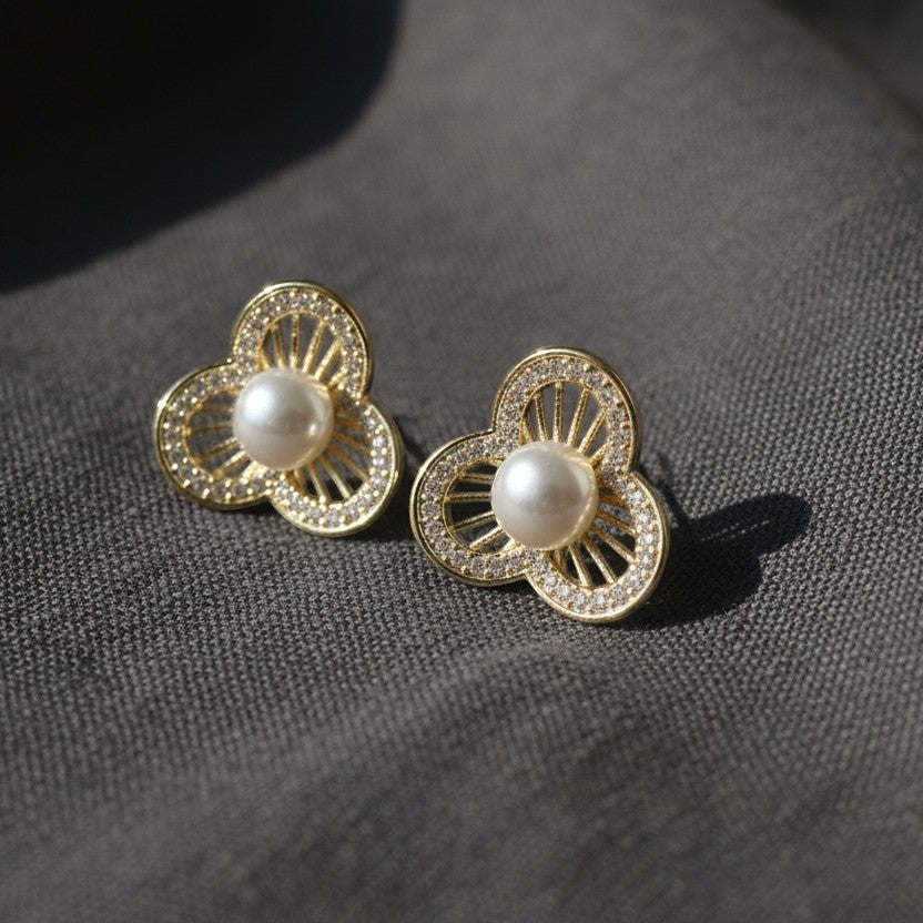 SVORA gold-tone stainless steel stud earrings with pearl center and crystal-embellished floral petals.