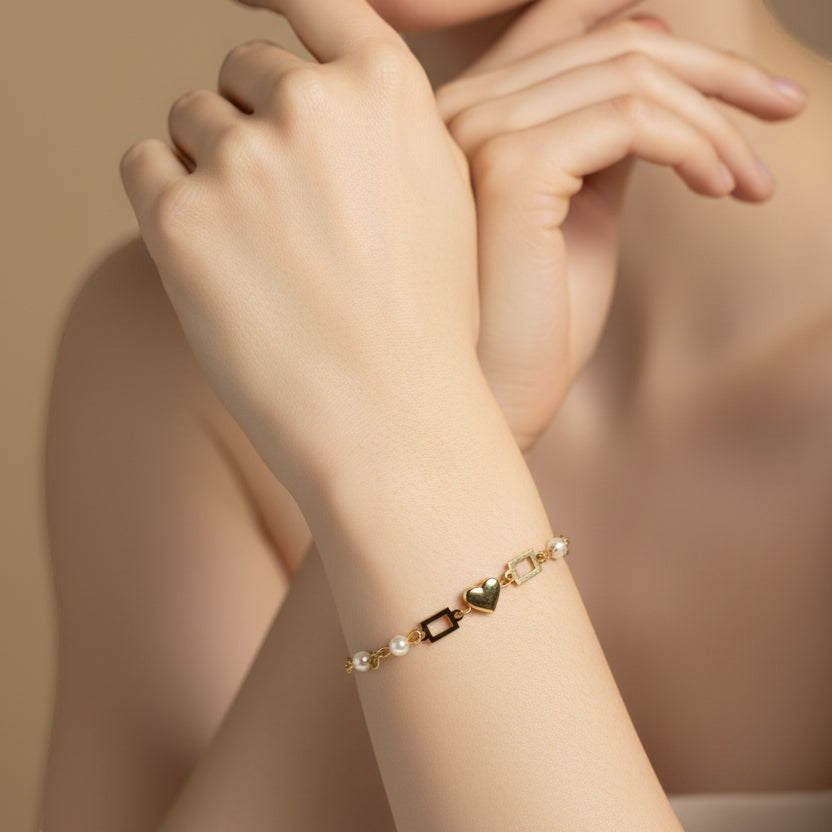 SVORA gold plated stainless steel bracelet with pearl and heart charms. Adjustable.