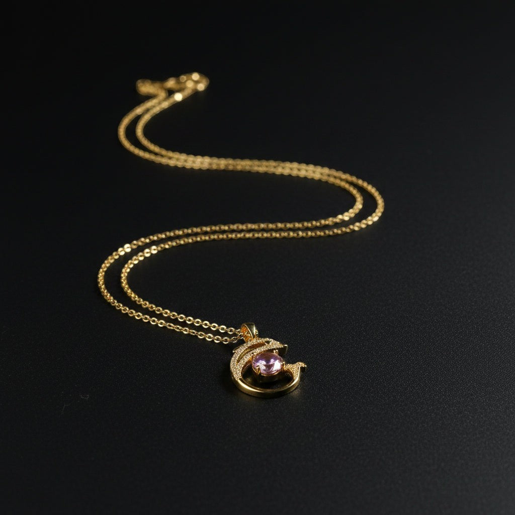 SVORA gold plated stainless steel necklace with a pink CZ solitaire pendant framed by a pavé dolphin.