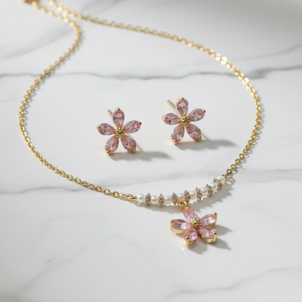 SVORA gold-tone necklace and earrings set with pink crystal flower charms and pearl accents.