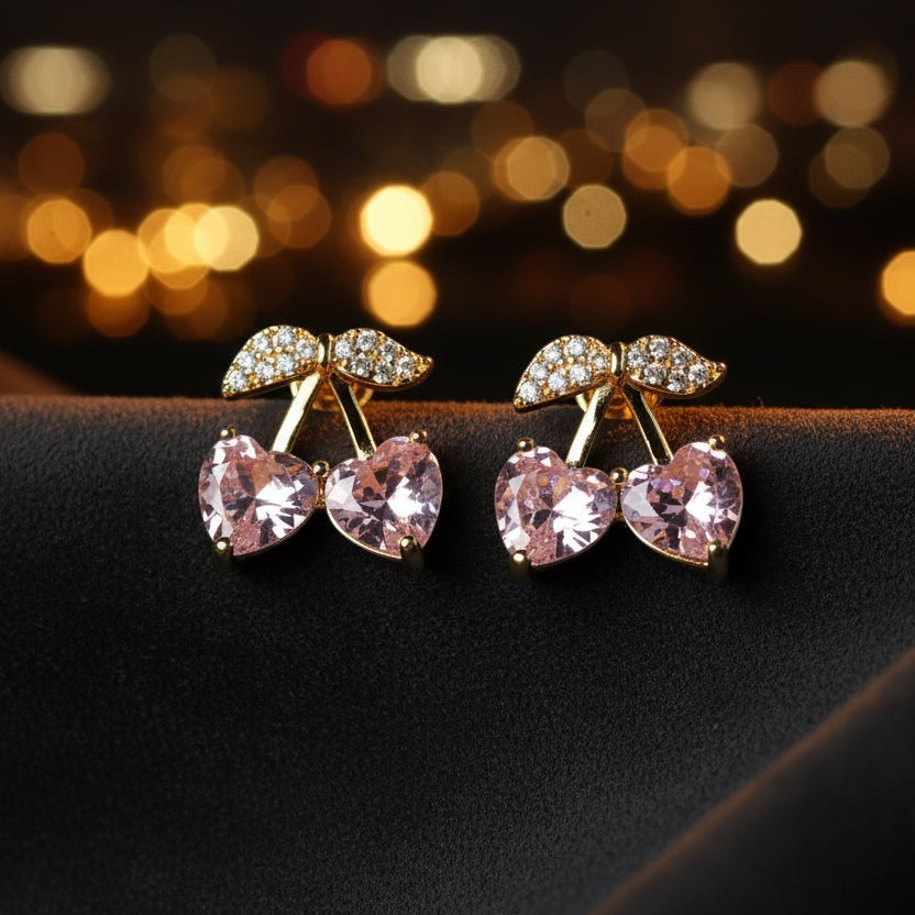 SVORA gold tone stud earrings with pink heart crystals and pave detail, resembling cherries.