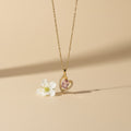 SVORA gold plated stainless steel necklace with a pink heart-shaped sapphire pendant surrounded by small clear crystals.