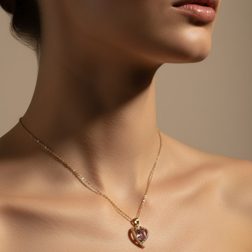 SVORA gold necklace with a pink heart-shaped sapphire pendant surrounded by small clear stones.