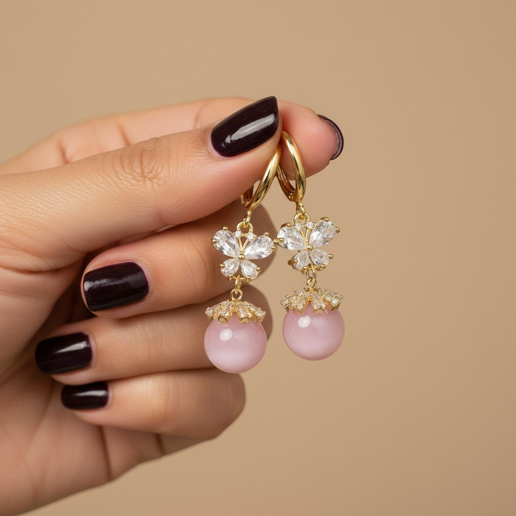 SVORA pink pearl butterfly dangle earrings with gold hoops and crystal accents.