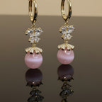 SVORA pink pearl butterfly dangler earrings with gold hoops and crystal accents.