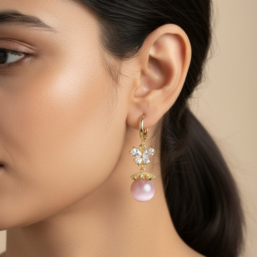 SVORA pink pearl butterfly dangler earrings with crystal accents and gold plating.