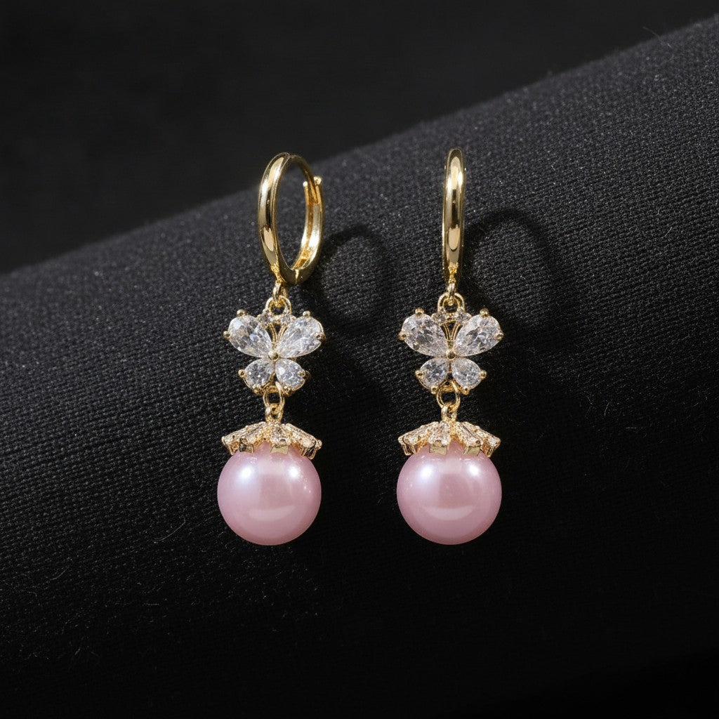 SVORA pink pearl butterfly dangler earrings with crystal accents and gold plating.