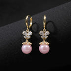 SVORA pink pearl butterfly dangler earrings with crystal accents and gold plating.