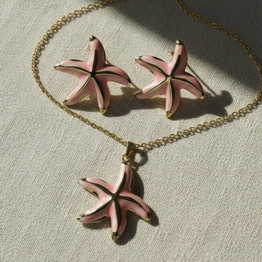 SVORA pink enamel starfish necklace and matching earrings set with gold-tone accents on a gold chain.