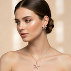 SVORA pink enamel starfish necklace and matching earrings with gold-tone accents, worn by a model.