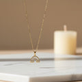 SVORA gold plated stainless steel necklace with a rainbow pendant adorned with baguette and round cubic zirconia stones, and cloud details.