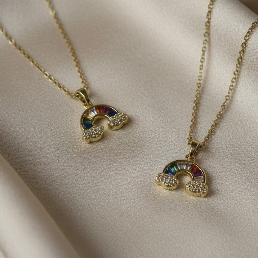 SVORA gold plated stainless steel rainbow necklace with colorful baguette stones and diamond accent clouds.