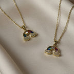 SVORA gold plated stainless steel rainbow necklace with colorful baguette stones and diamond accent clouds.