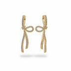 SVORA gold-tone stainless steel dangle earrings with ribbon knot design and pave set cubic zirconia.