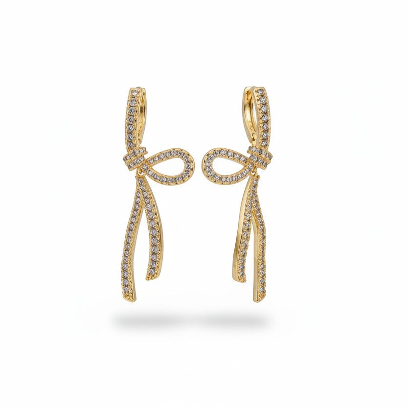 SVORA gold-tone stainless steel dangle earrings with ribbon knot design and pave set cubic zirconia.