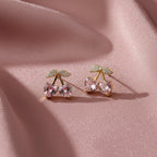 SVORA gold tone stud earrings with pink heart-shaped crystals and clear crystal accents, resembling cherries.