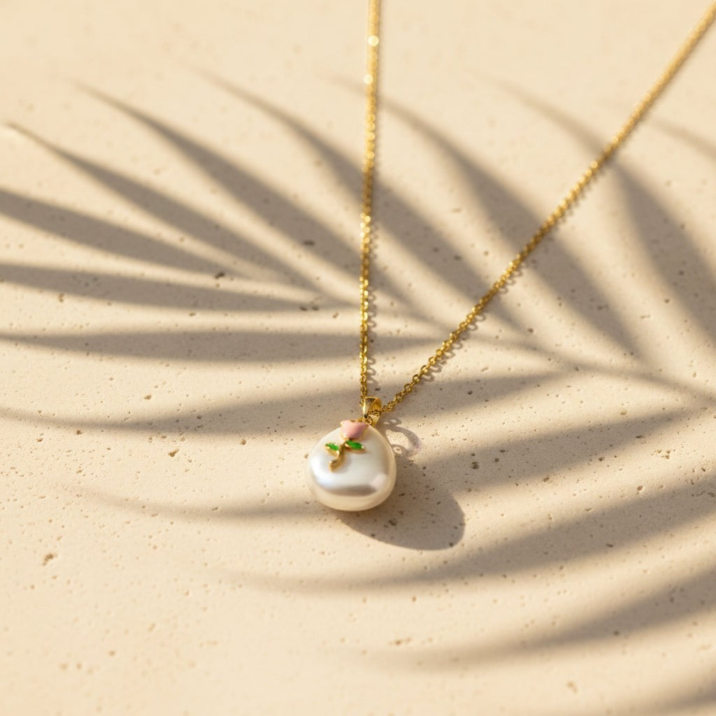 SVORA gold chain necklace with a baroque pearl pendant featuring a pink rose and green leaves design.