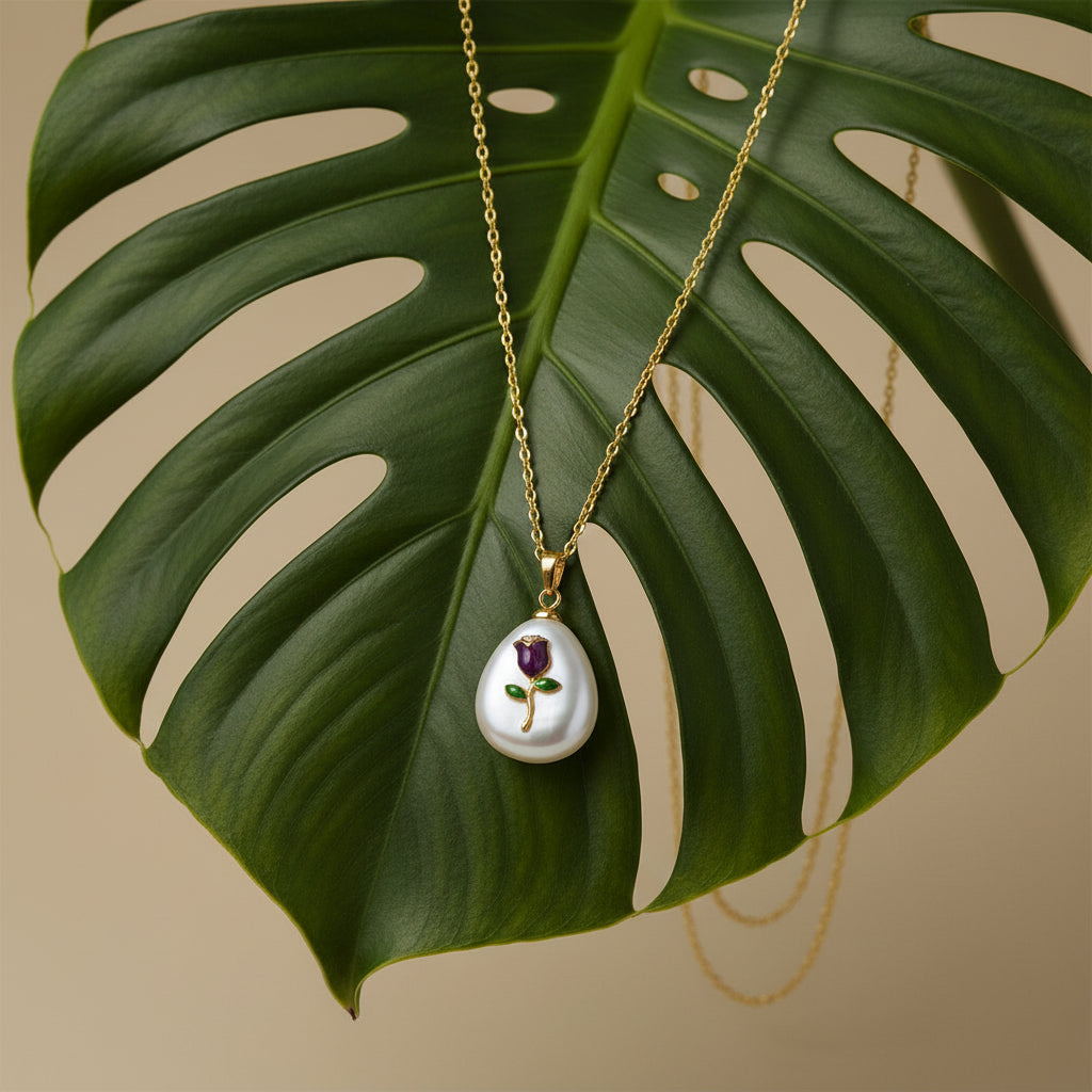 SVORA amethyst-purple enamel rose pendant with gold stem and green leaves on a white baroque pearl, gold chain necklace.
