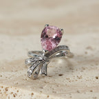 SVORA Ethereal Rose Ribbon Ring with a pear-cut pink stone and pavé clear stones on a silver band.