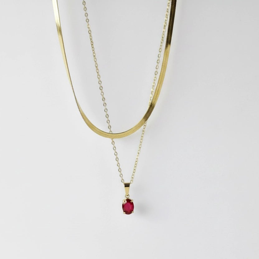 SVORA layered gold snake chain necklace with a ruby red crystal pendant. Stainless steel, 18k gold plated.