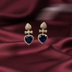 SVORA gold-tone earrings with sapphire blue crystal heart drops and pavé details.