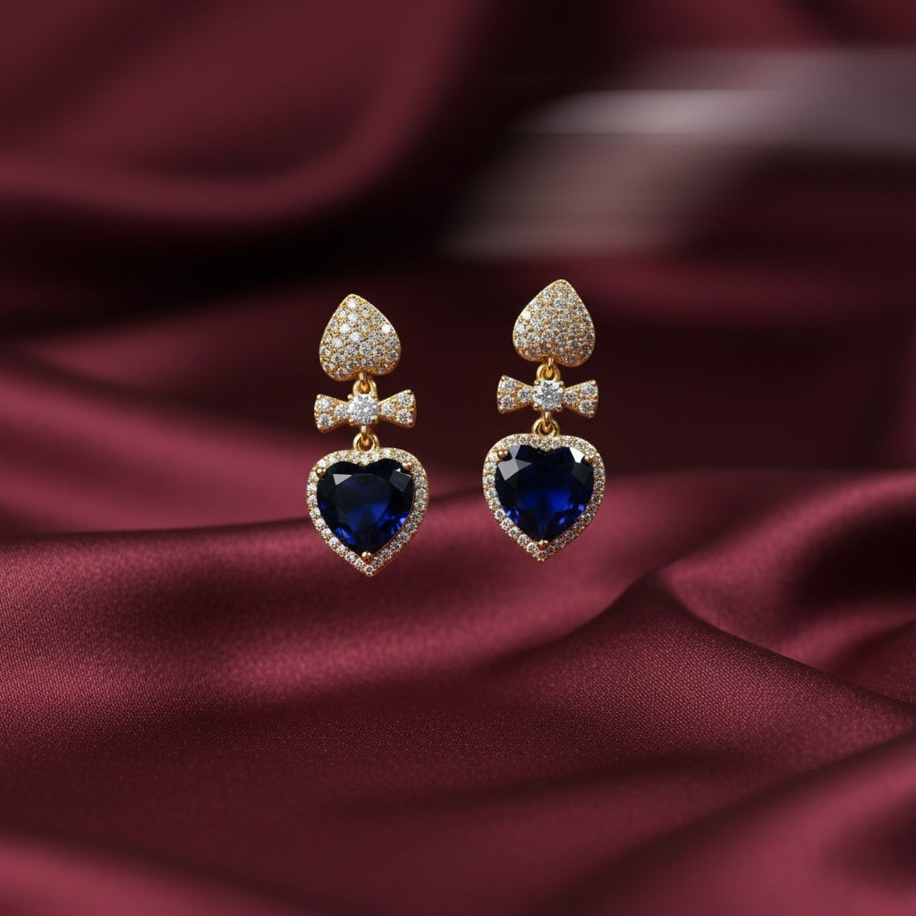 SVORA gold-tone earrings with sapphire blue crystal heart drops and pavé details.