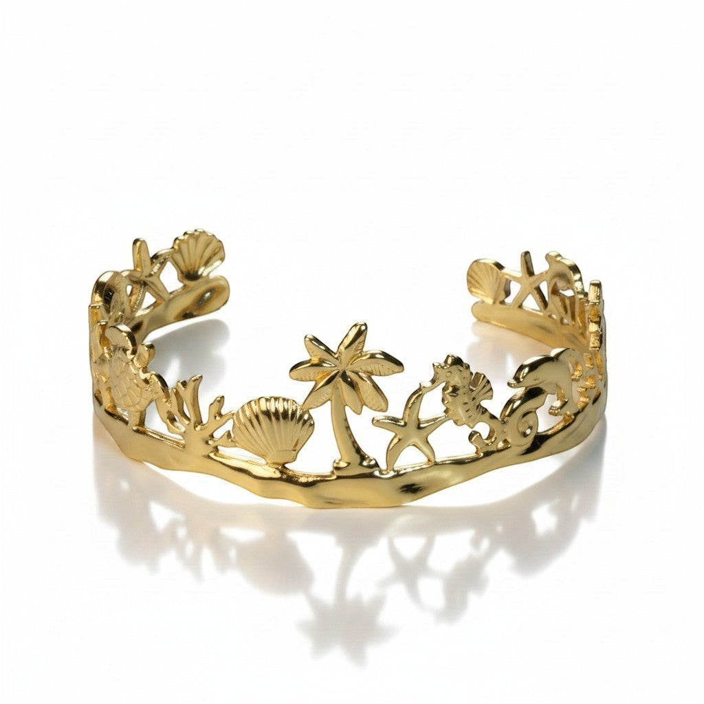 SVORA gold plated stainless steel Seascape cuff bracelet with palm trees, shells, turtles, and dolphins.