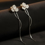 SVORA silver-tone stud earrings with three-petal flower design, pavé-set with cubic zirconia and a central pearl.