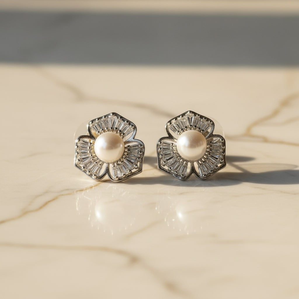 SVORA silver-tone stud earrings with five petal flower design, baguette cubic zirconia petals, and a pearl center.