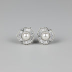 SVORA silver-tone stud earrings shaped like five-petal flowers with baguette cubic zirconia petals and a pearl center.