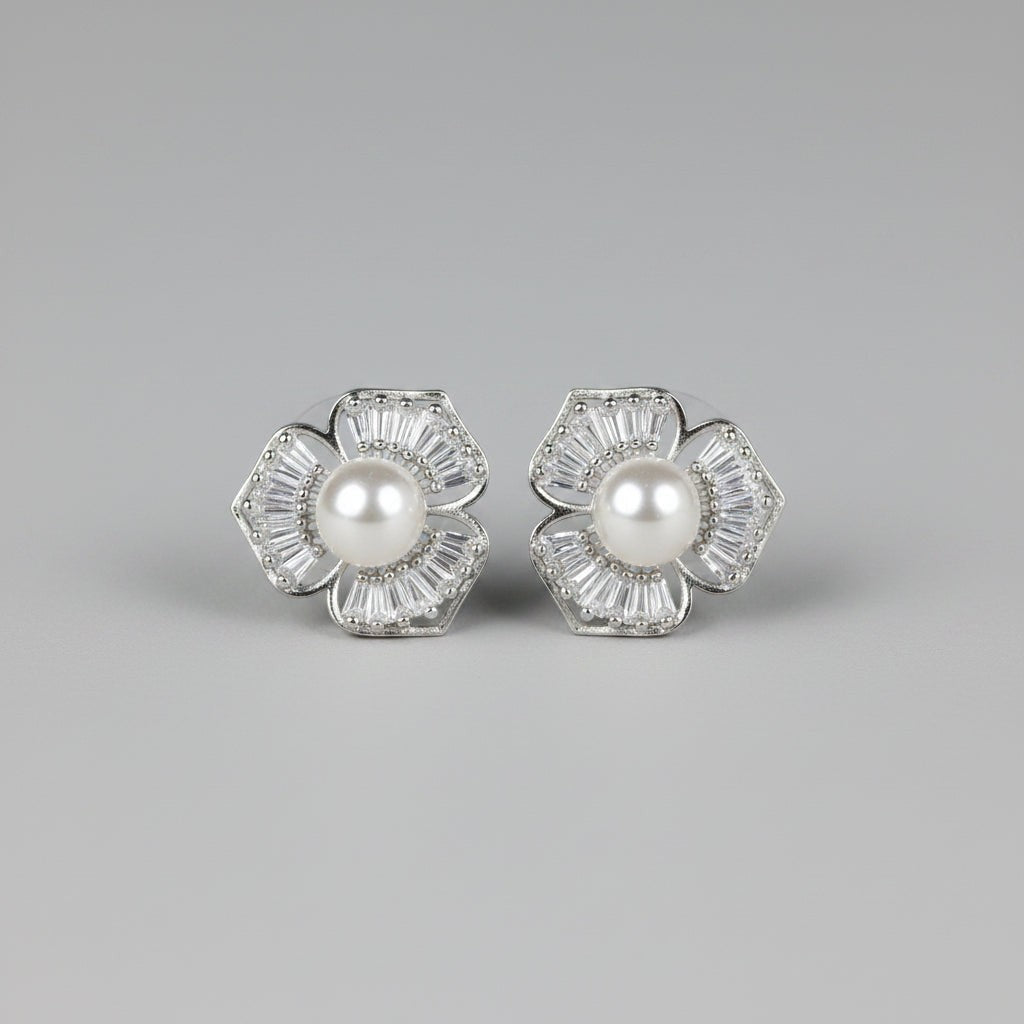 SVORA silver-tone stud earrings shaped like five-petal flowers with baguette cubic zirconia petals and a pearl center.