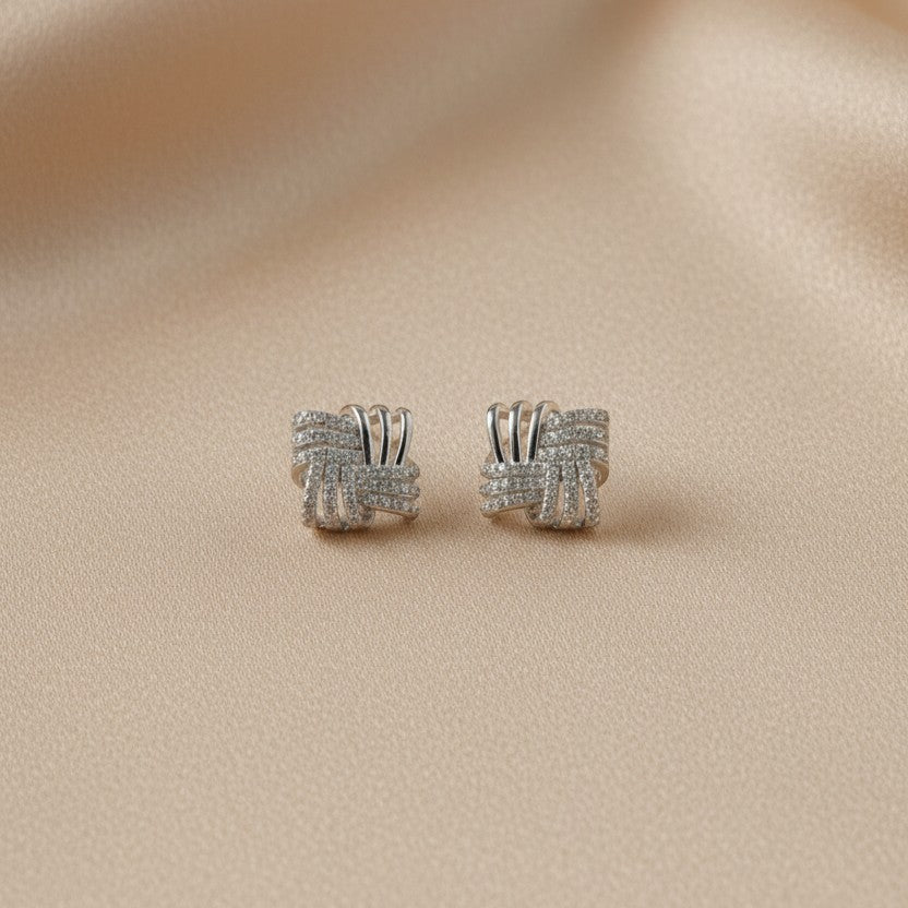 SVORA silver square stud earrings with interlocking design and cubic zirconia stones.