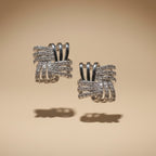 SVORA silver rhodium-plated stainless steel stud earrings with interlocking square design and cubic zirconia stones.