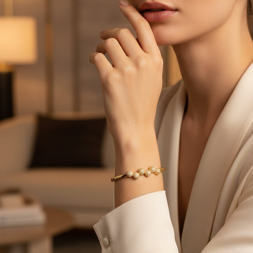 SVORA gold plated stainless steel bangle bracelet with six pavé cubic zirconia domes. Modern, waterproof jewelry.