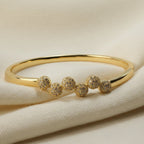 SVORA gold plated stainless steel bangle bracelet with six pavé cubic zirconia domes in a row. Modern, waterproof jewelry.
