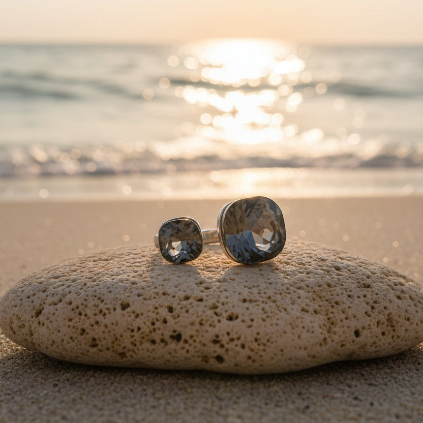 SVORA Toi et Moi ring with two smoky topaz stones on a slim silver band, set on a rock at the beach.