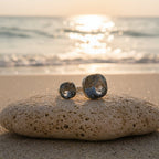 SVORA Toi et Moi ring with two smoky topaz stones on a slim silver band, set on a rock at the beach.