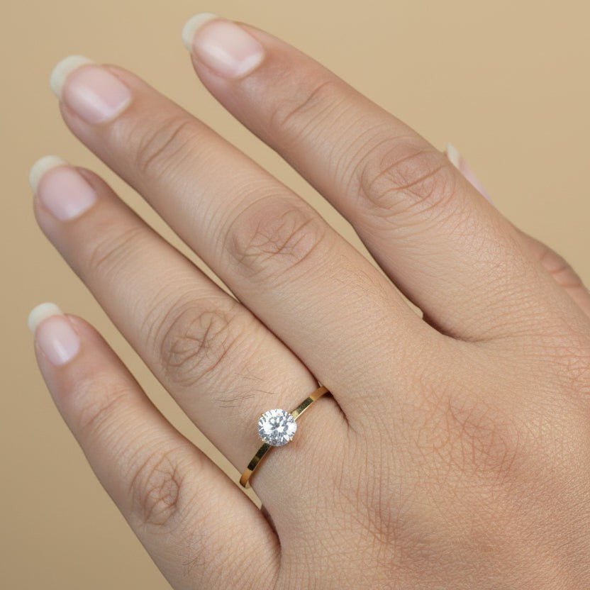 SVORA Lumiere Whisper Solitaire Ring in gold tone, featuring a round cubic zirconia set in 316L stainless steel with 18K gold plating.