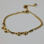 SVORA gold curb chain bracelet with seven heart charms, four textured and three solid. Adjustable lobster clasp.