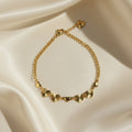 SVORA gold curb chain bracelet with seven hearts, four textured sunburst and three solid. Adjustable.