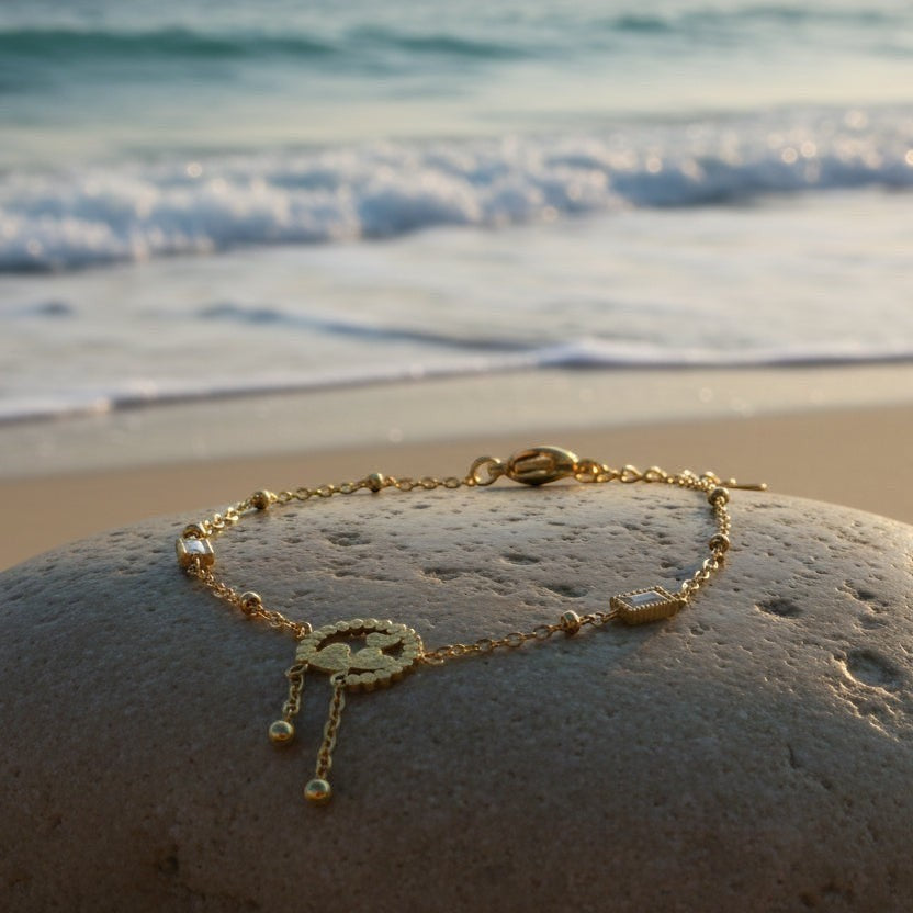 SVORA gold plated stainless steel bracelet with three hearts charm and baguette CZs, adjustable clasp.