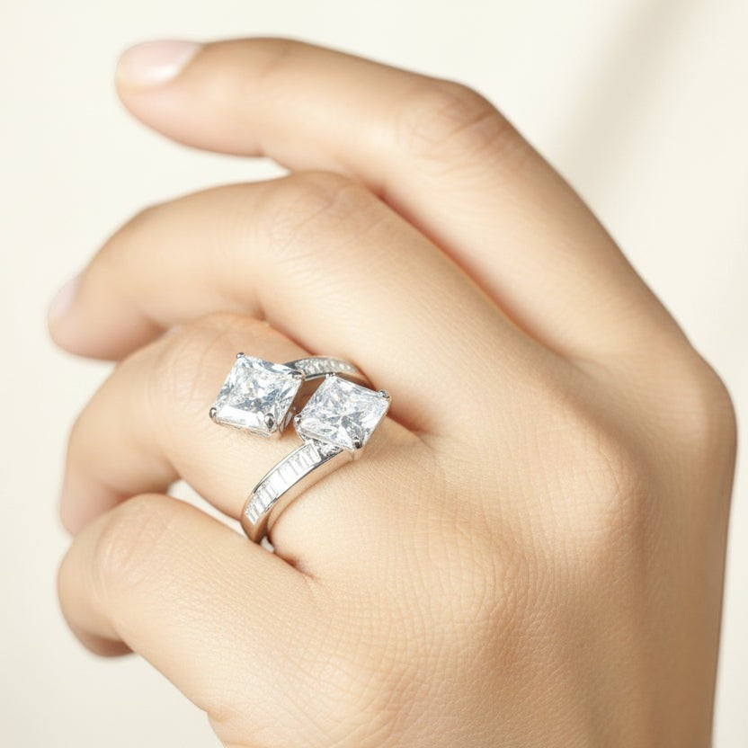 SVORA Toi et Moi ring with two princess-cut clear stones and channel-set baguettes on a rhodium-plated band.