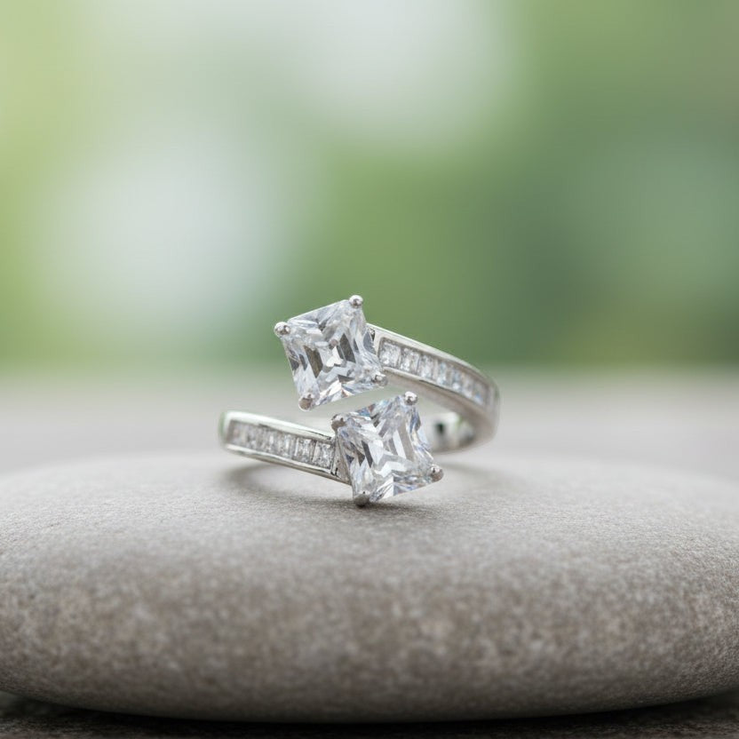 SVORA Toi et Moi ring with two princess-cut clear stones and channel-set baguettes on a rhodium-plated band.
