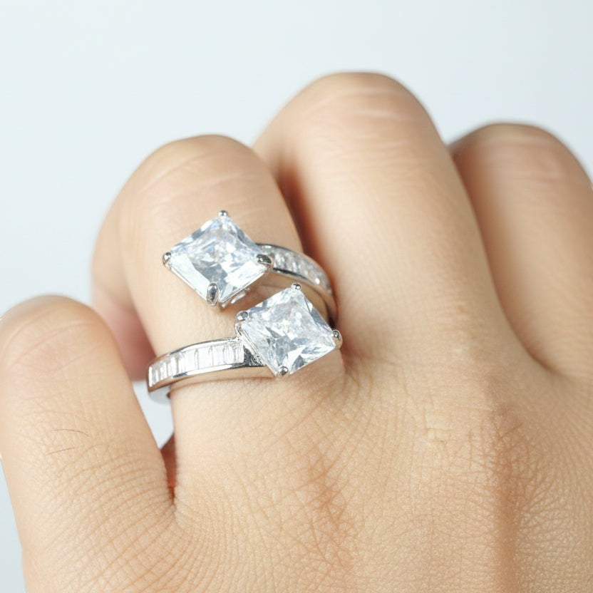 SVORA Toi et Moi ring with two princess-cut clear stones and channel-set baguettes on a rhodium-plated band.