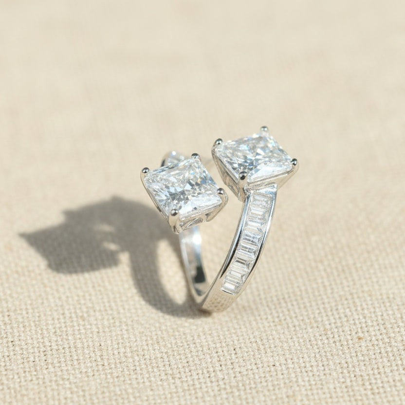 SVORA Toi et Moi ring with two princess-cut clear stones and channel-set baguettes on a rhodium-plated band.