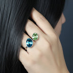 SVORA Toi et Moi ring with oval sapphire blue and emerald green stones on a silver band. Adjustable.