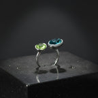 SVORA Toi et Moi ring with oval sapphire blue and emerald green stones, rhodium-plated stainless steel, adjustable band.
