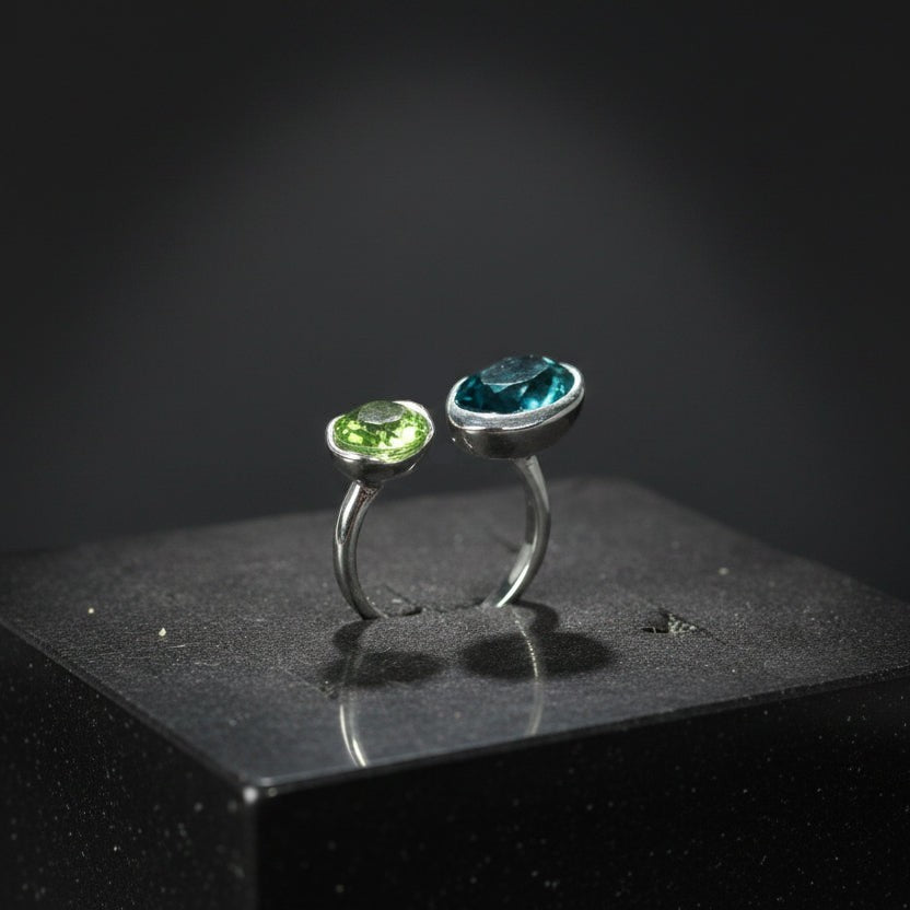 SVORA Toi et Moi ring with oval sapphire blue and emerald green stones, rhodium-plated stainless steel, adjustable band.