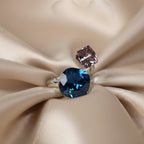 SVORA Toi et Moi ring with blue cushion and purple cube tanzanite stones on silver band.