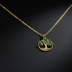 SVORA gold plated stainless steel pendant necklace with a Tree of Life design featuring emerald marquise CZ leaves and white CZ accents.